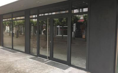 Dunkle Fenster- und Türelemente mit großflächiger Verglasung an einer Gebäudefassade