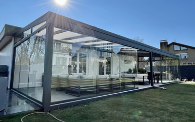 Freistehender Kaltwintergarten mit großflächiger Verglasung und dunkler Aluminiumkonstruktion