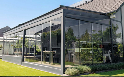 Geschlossener Kaltwintergarten mit Glasschiebeelementen und Blick in den Garten