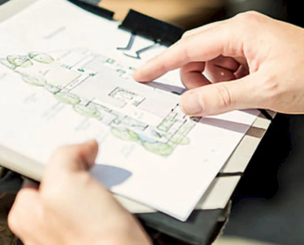 Hände halten eine Mappe mit einem Gartenplan