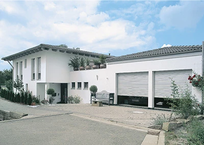 Ein großes weißes Haus mit zwei Garagen