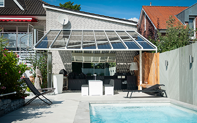Terrassenüberdachung mit Glasdach und Beschattung direkt am Pool