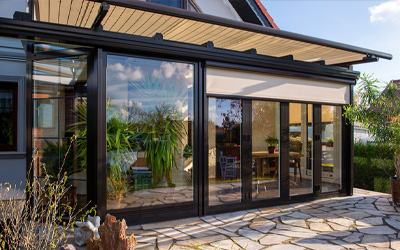 Wintergarten mit Aluminiumrahmen, Ganzglasschiebeanlagen und integrierter Beschattung am Wohnhaus