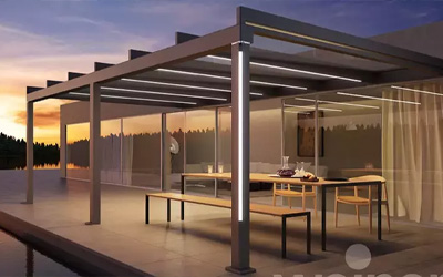 Lamellendach mit integrierter Beleuchtung, moderner Outdoor-Essbereich bei Sonnenuntergang.