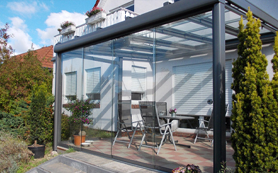 Moderner Sommergarten mit Glasfronten und schwarzem Aluminiumrahmen
