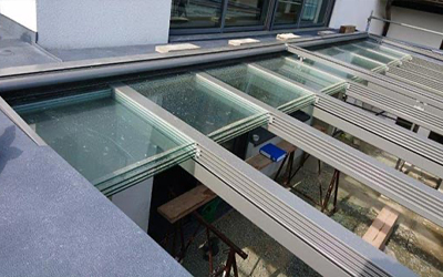 Terrassenüberdachung mit integriertem Senkrecht-Screen als seitlicher Sonnen- und Sichtschutz im Garten.