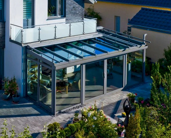 Wintergarten mit Glasdach und Schiebetüren als erweiterter Wohnraum im Garten