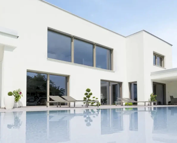 Moderne Fenster an einem weißen großen Haus mit Pool