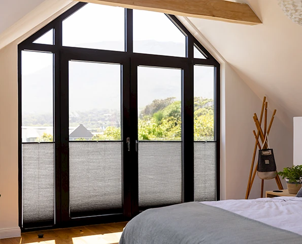 Plissee in grau vor einem großem Fenster