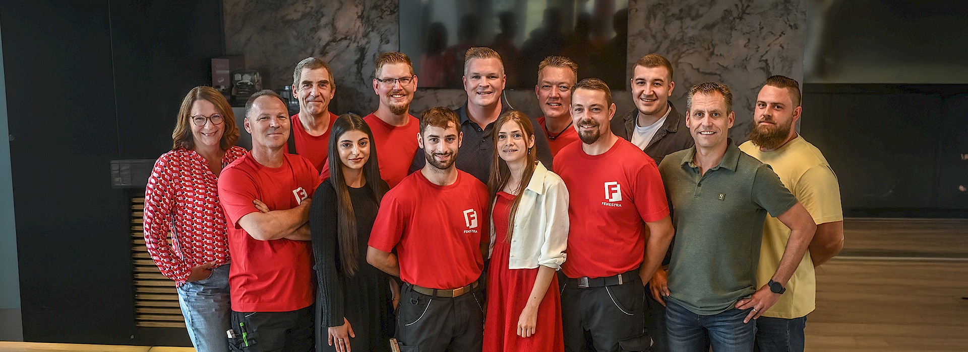 Gruppenfoto des Fenestra-Teams mit Mitarbeitern in Firmenkleidung und lächelnden Gesichtern.