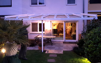 Terrassenüberdachung in weiß am Abend