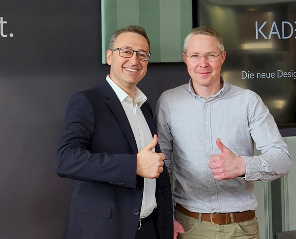 Zwei Personen stehen an einem Tisch mit und planen