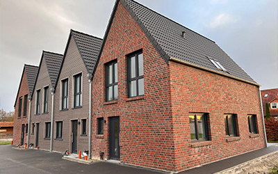 Moderne Reihenhäuser mit Backsteinfassade und dunklen Fenstern