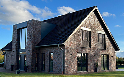 Einfamilienhaus mit Backsteinfassade, großen Fenstern und moderner Architektur