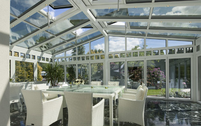 Weißer Wintergarten mit Tisch und Stühlen in der Mitte