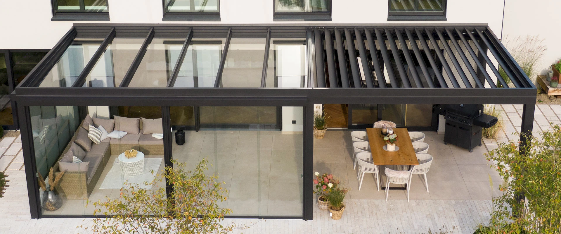 Drohnenbild eines Sommergartens mit Lamellendach am Haus