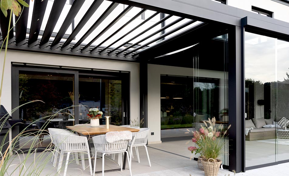 Seitenansicht modernes, weißes Wohnhaus mit einem kubischen Lamellendach und Flachdach.