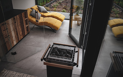 Moderner Modulraum mit Saunaofen, Glasfront und Relaxliegen für Wellness im eigenen Garten.