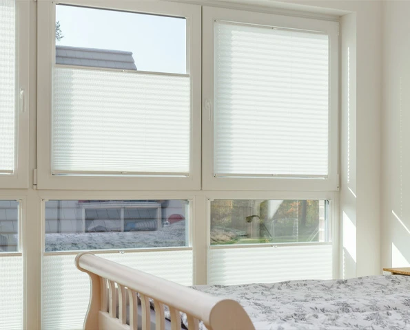 Innenliegende Plissees als flexibler Sicht- und Sonnenschutz für Fenster im Wohnbereich.