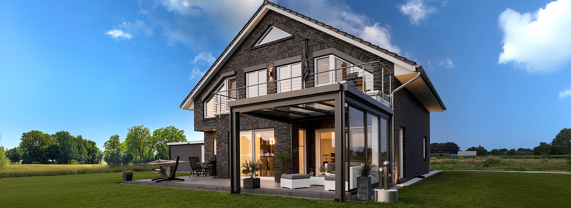 Einfamilienhaus mit eleganter Glas-Terrassenüberdachung und seitlichen Schiebeelementen, modernes Outdoor-Wohnzimmer