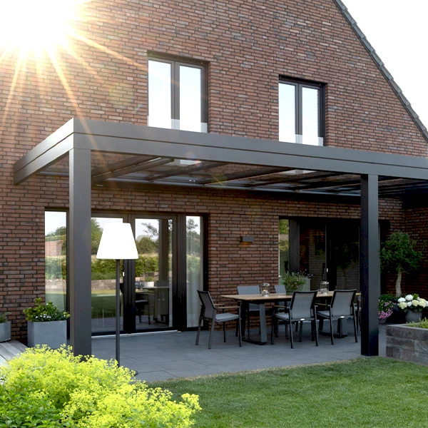 Modernes Terrassendach mit Flachdach-Design und Glasüberdachung an einem Backsteinhaus