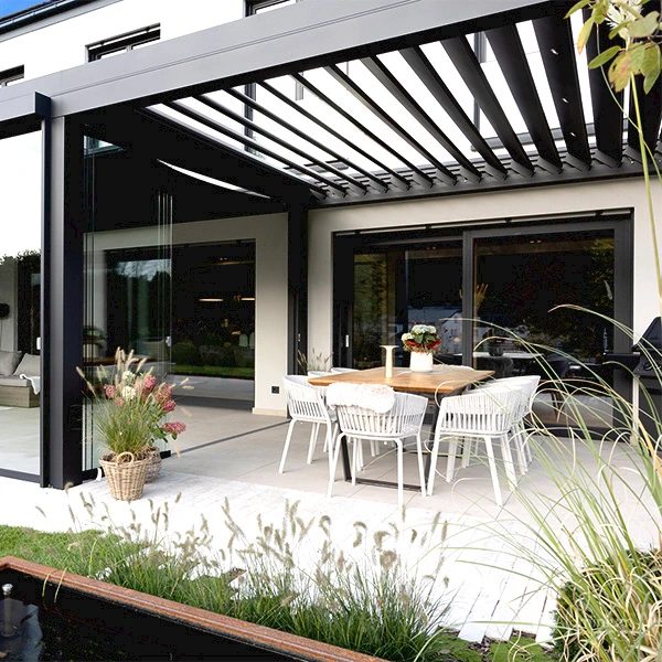 Sommergarten mit Glasdach und seitlichen Glaselementen an einem Wohnhaus