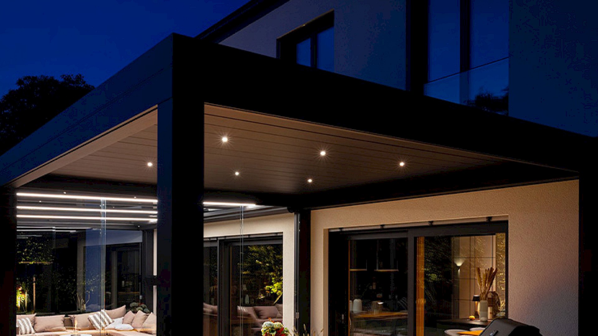Modernes Lamellendach mit integrierter LED-Beleuchtung und Spots, die abends für stimmungsvolles Licht auf der Terrasse sorgen.