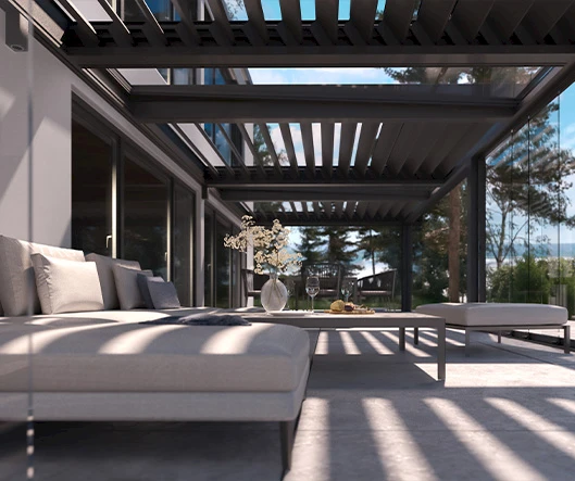 Gemütliche Lounge unter einem modernen Lamellendach mit Glaswänden und bequemen Polstermöbeln.