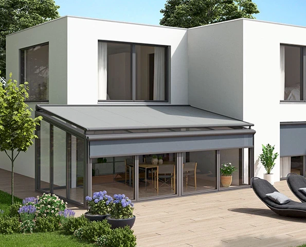 Wintergarten mit außenliegender Markise und bodentiefen Glaswänden an einem kubischen Neubau.