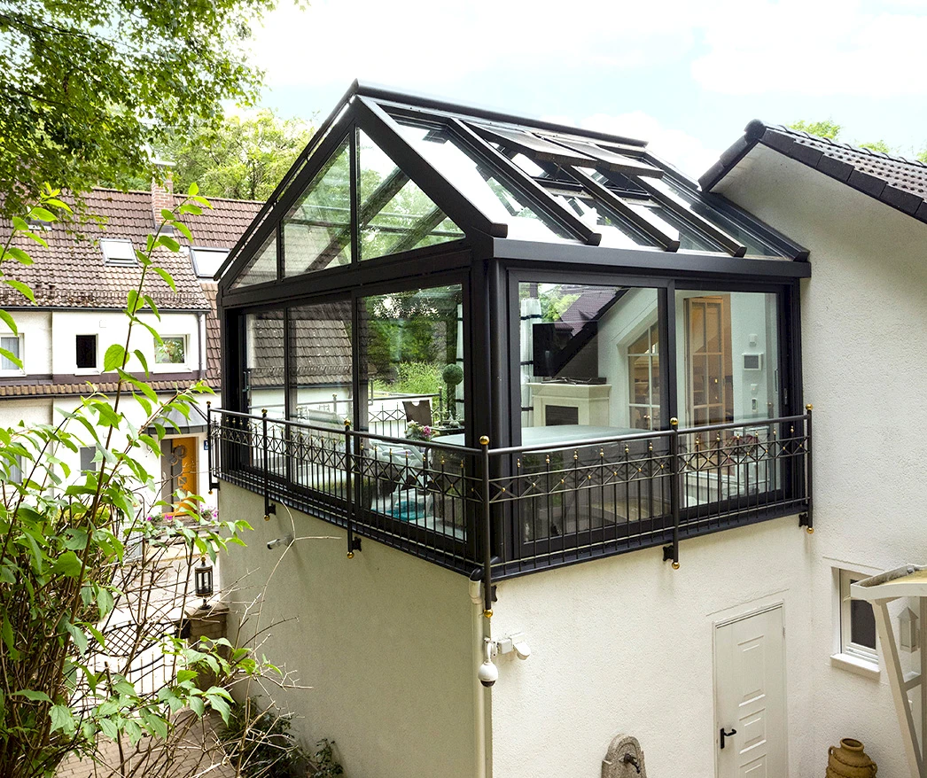 Aufgesetzter Wintergarten mit Glas-Satteldach auf einem Balkon, elegante Erweiterung des Wohnraums.