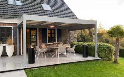 Überdachte Terrasse mit Infrarot-Heizstrahlern und gemütlicher Sitzgruppe im Garten eines Einfamilienhauses.