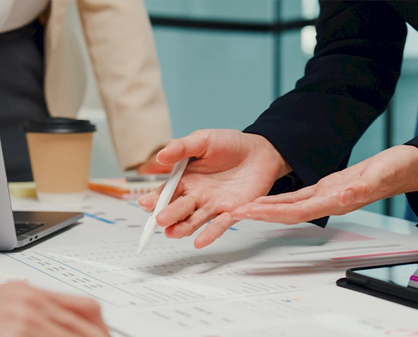 Projektplanung im Büro mit Unterlagen und Diagrammen, detaillierte Abstimmung im Planungsteam.