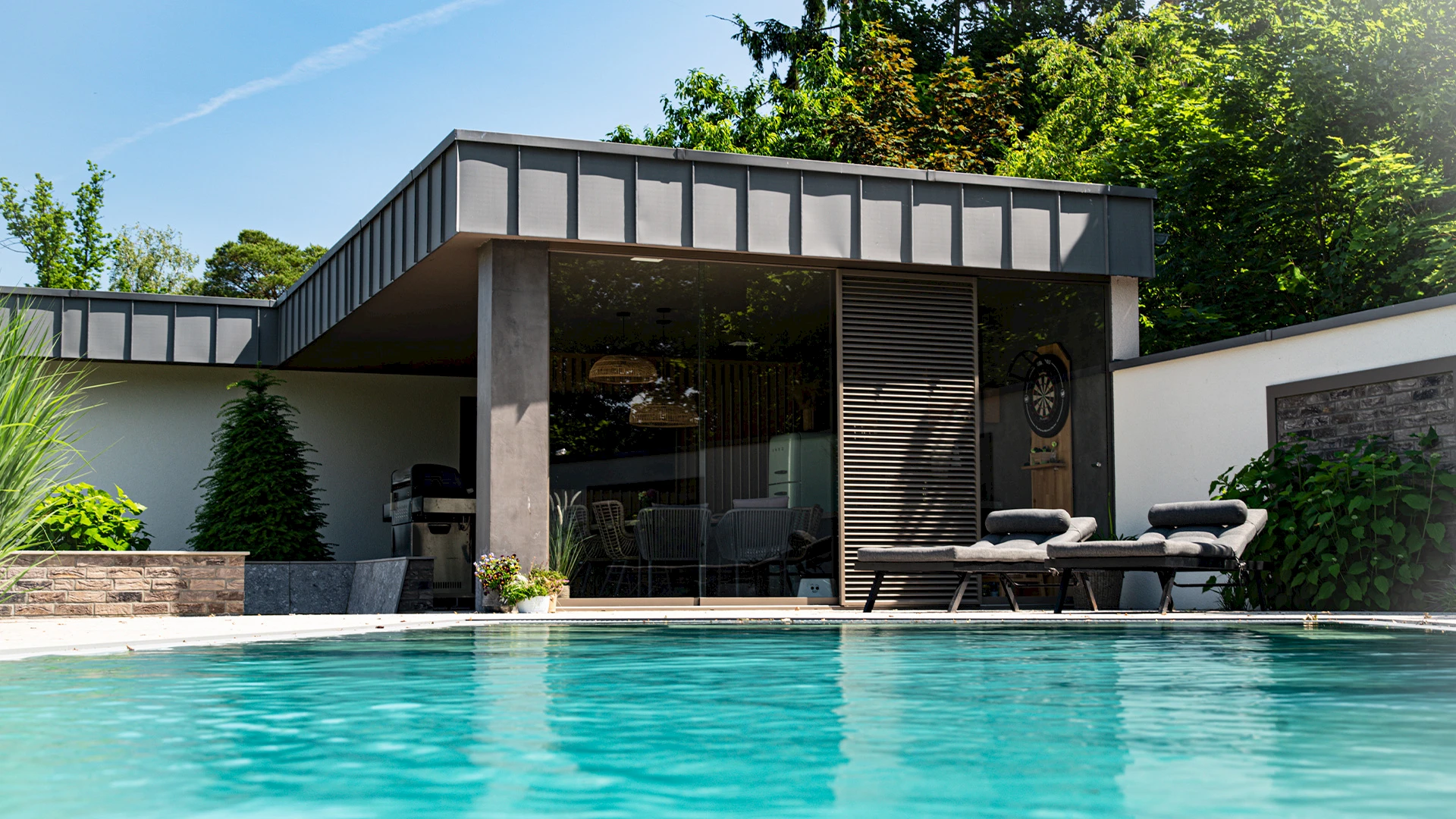 Exklusiver Modulraum mit Glasfront am Pool – stilvolle Gartenlounge mit moderner Architektur.