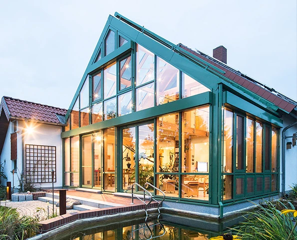 Großzügiger Wintergarten mit Glasfronten und Satteldach – ganzjährig nutzbarer Wohnraum im Grünen.