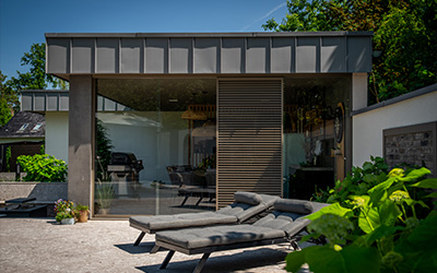 Eleganter Modulraum mit Glasfront und moderner Einrichtung, ideal als Gartenlounge oder Büro.