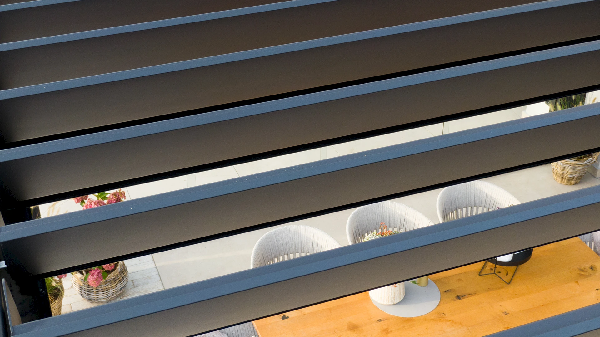 Modernes Lamellendach als Terrassenüberdachung mit Essbereich und Sitzlounge