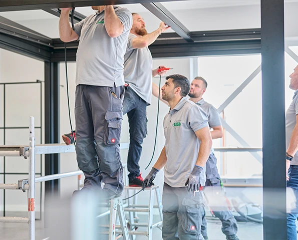 Zwei Personen stehen an einem Tisch mit und planen