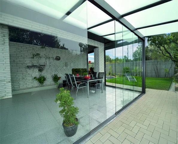 Überdachter Sitzbereich mit großflächigen Glasschiebetüren und Blick in den Garten.