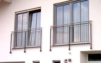 Französischer Balkon mit Edelstahlgeländer an moderner Hausfassade mit großen Fenstern