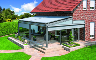 Großes Terrassendach aus Aluminium mit integrierter Markise über Sitzbereich am Einfamilienhaus