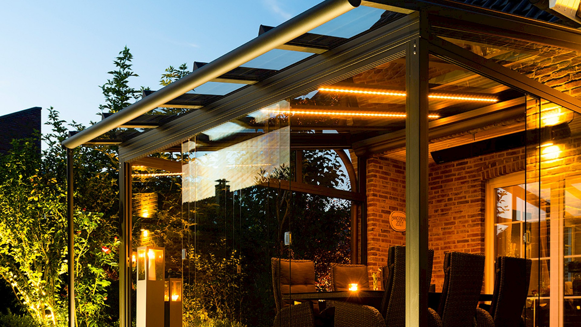 Modernes Lamellendach mit integrierter LED-Beleuchtung und Spots, die abends für stimmungsvolles Licht auf der Terrasse sorgen.