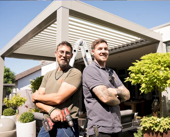 Montageteam vor installiertem Aluminium-Lamellendach auf Terrasse