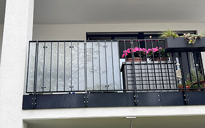 Balkongeländer aus Metall mit integriertem satiniertem Sichtschutzglas