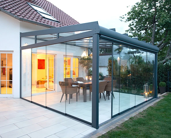 Sommergarten mit Glasschiebetüren als geschützter Wohnraum im Außenbereich