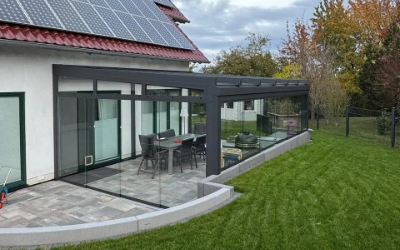Kaltwintergarten mit umlaufender Verglasung und Terrassenanbindung am Einfamilienhaus