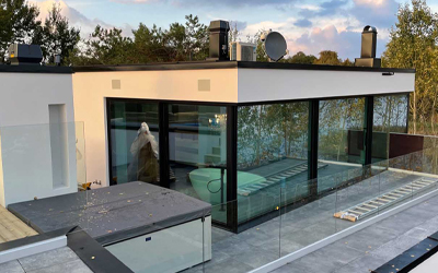 Moderner Wohnhaus-Anbau mit großflächiger Glasfassade und bodentiefen Schiebeelementen