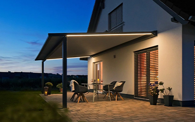Beleuchtetes Terrassendach mit gemütlichem Sitzbereich am Abend