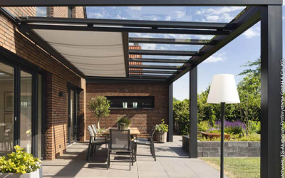Moderne Terrassenüberdachung mit Glasdach, integrierter Beschattung und Essplatz im Garten