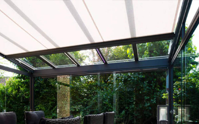 Terrassenüberdachung mit Glasdach, innenliegender Beschattung und seitlichen Glaswänden