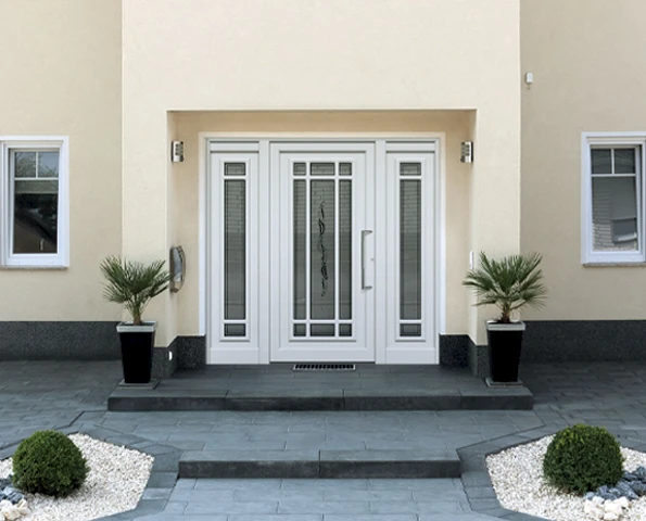 Große Haustür in weiß an einer gelblichen Fassade